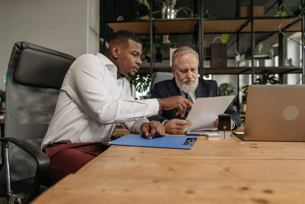 A young professional in discussion with a senior business mentor in an office setting